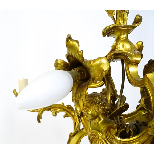 1435 - A gilt metal pendant chandelier / electrolier with acanthus scroll and cherub detail, having three c... 