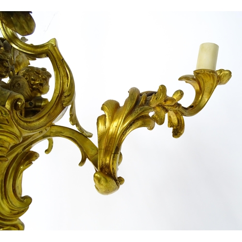 1435 - A gilt metal pendant chandelier / electrolier with acanthus scroll and cherub detail, having three c... 