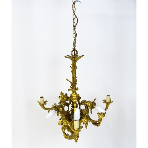 1435 - A gilt metal pendant chandelier / electrolier with acanthus scroll and cherub detail, having three c... 