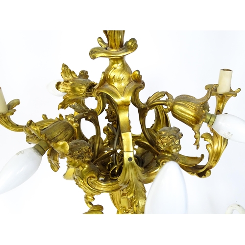 1435 - A gilt metal pendant chandelier / electrolier with acanthus scroll and cherub detail, having three c... 