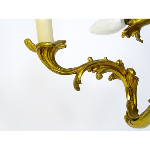 1435 - A gilt metal pendant chandelier / electrolier with acanthus scroll and cherub detail, having three c... 