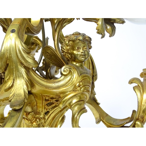 1435 - A gilt metal pendant chandelier / electrolier with acanthus scroll and cherub detail, having three c... 