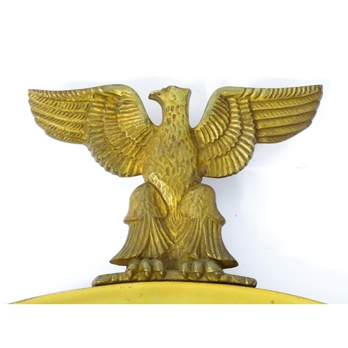 1456 - A 20thC brass wall mirror surmounted by an eagle and with laurel wreath decoration. 26