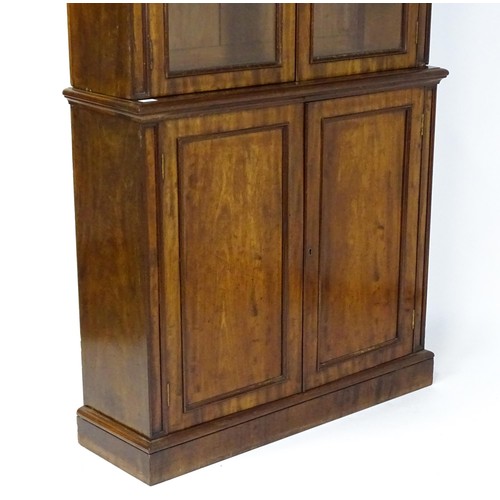 1457 - A 19thC mahogany bookcase with a moulded cornice and two glazed doors with arched panels, the base h... 