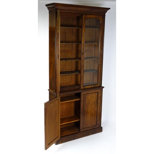 1457 - A 19thC mahogany bookcase with a moulded cornice and two glazed doors with arched panels, the base h... 