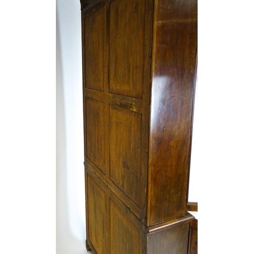 1457 - A 19thC mahogany bookcase with a moulded cornice and two glazed doors with arched panels, the base h... 