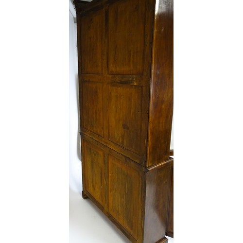 1457 - A 19thC mahogany bookcase with a moulded cornice and two glazed doors with arched panels, the base h... 