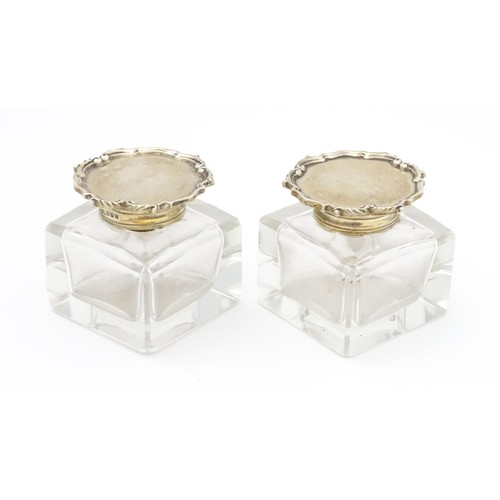 484A - A pair of glass inkwells with silver tops hallmarked London 1928, maker Mappin & Webb Ltd. Approx. 2... 