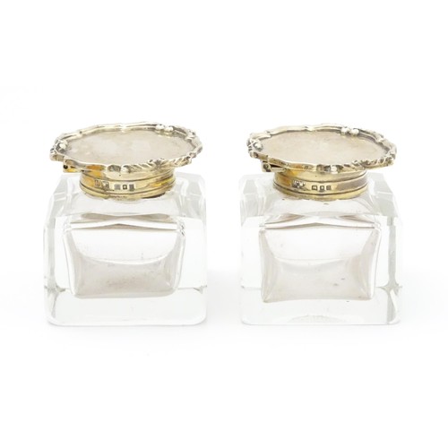 484A - A pair of glass inkwells with silver tops hallmarked London 1928, maker Mappin & Webb Ltd. Approx. 2... 