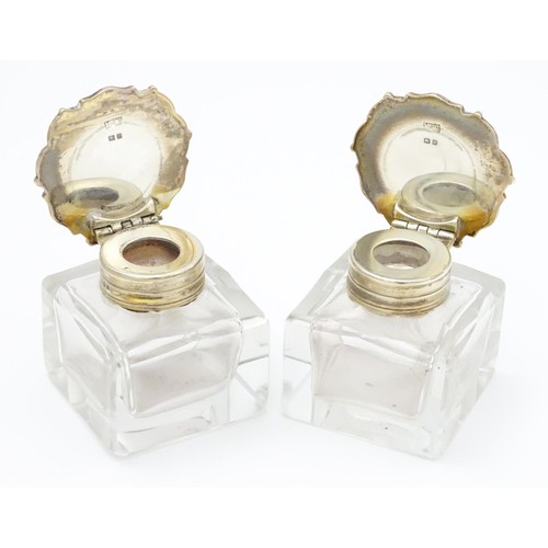 484A - A pair of glass inkwells with silver tops hallmarked London 1928, maker Mappin & Webb Ltd. Approx. 2... 