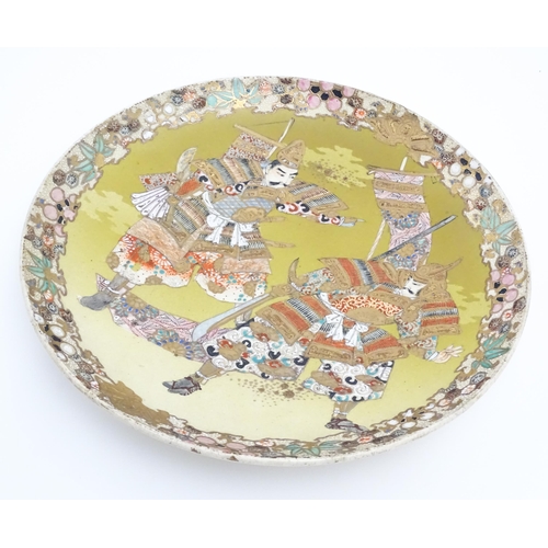 204 - A Japanese Satsuma charger decorated with two Samurai warriors. Character marks under. Approx. 12 1/... 