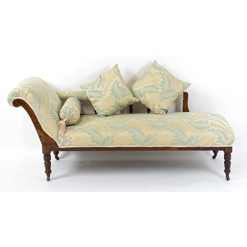 1458 - An early / mid 20thC chaise longue with a scrolled end and upholstered backrest with turned supports... 