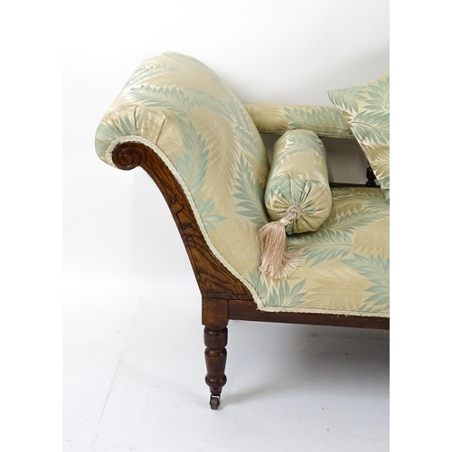 1458 - An early / mid 20thC chaise longue with a scrolled end and upholstered backrest with turned supports... 