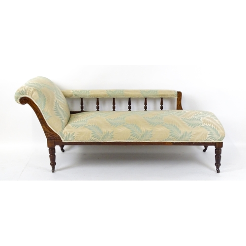 1458 - An early / mid 20thC chaise longue with a scrolled end and upholstered backrest with turned supports... 