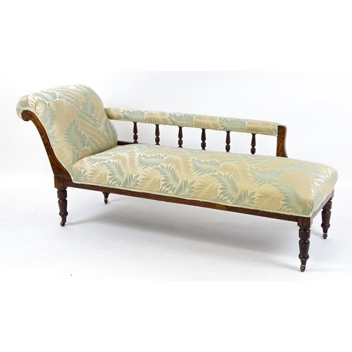 1458 - An early / mid 20thC chaise longue with a scrolled end and upholstered backrest with turned supports... 