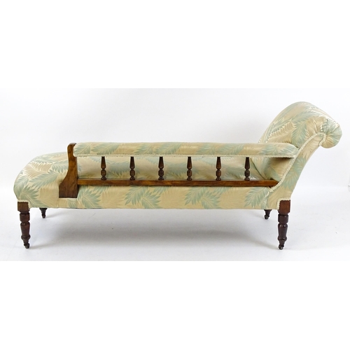 1458 - An early / mid 20thC chaise longue with a scrolled end and upholstered backrest with turned supports... 