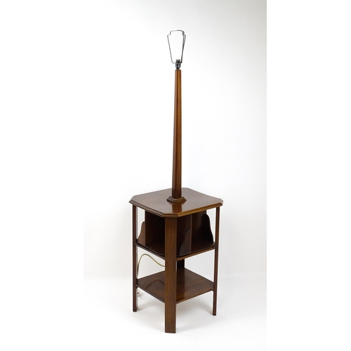 1514 - An Art Deco mahogany lamp stand with a canted stem above a three tier table base with a revolving bo... 