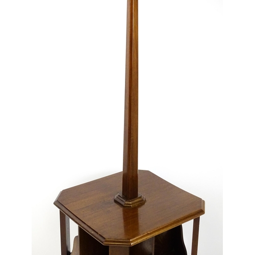 1514 - An Art Deco mahogany lamp stand with a canted stem above a three tier table base with a revolving bo... 