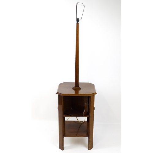 1514 - An Art Deco mahogany lamp stand with a canted stem above a three tier table base with a revolving bo... 