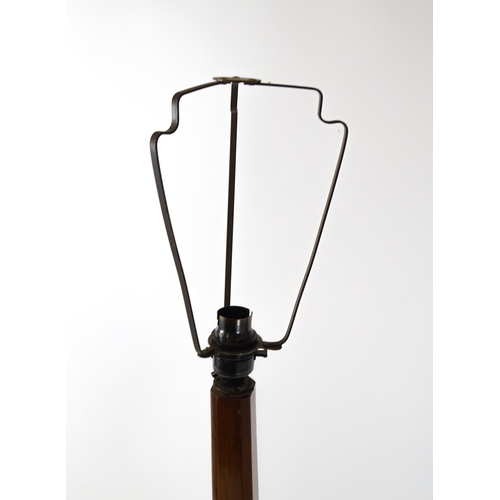 1514 - An Art Deco mahogany lamp stand with a canted stem above a three tier table base with a revolving bo... 