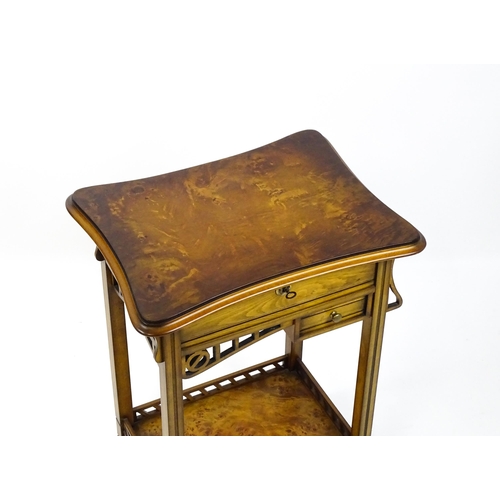 1515 - A late 20thC sewing table with a hinged top opening to show fitted compartments, a mirror, and an ad... 