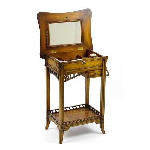 1515 - A late 20thC sewing table with a hinged top opening to show fitted compartments, a mirror, and an ad... 