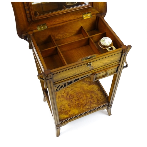 1515 - A late 20thC sewing table with a hinged top opening to show fitted compartments, a mirror, and an ad... 