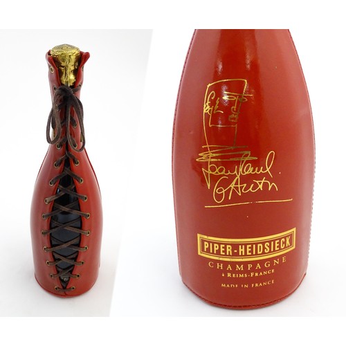 1123 - A 1999 limited edition 75cl bottle of Piper-Heidsieck champagne in a Jean-Paul Gaultier red PVC cors... 