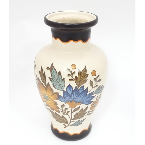 34 - A Gouda vase with floral and foliate decoration. Marked under Flora Gouda Plateel Holland Handwerk, ... 