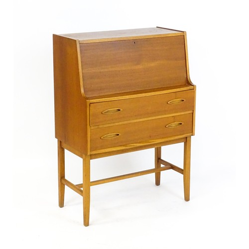 70 - Vintage / Retro: A teak desk, bureau with a fall front above two short drawers raised on four taperi... 