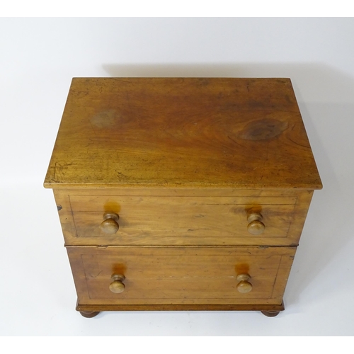 81 - A 19thC mahogany commode with a hinged top, four turned knob handles and raised on four turned feet.... 