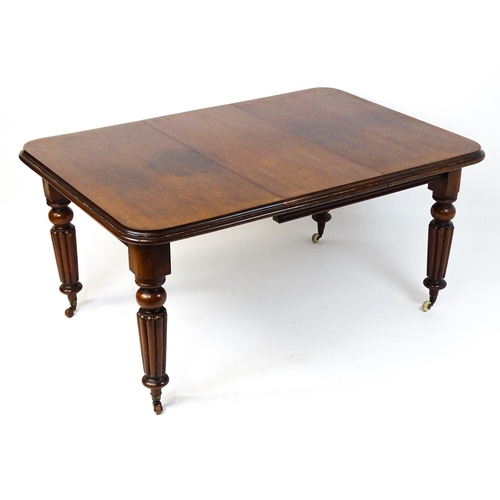 260 - A late 19thC mahogany dining table raised on four turned tapering legs terminating in porcelain cast... 