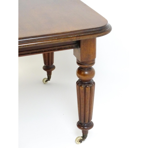 260 - A late 19thC mahogany dining table raised on four turned tapering legs terminating in porcelain cast... 