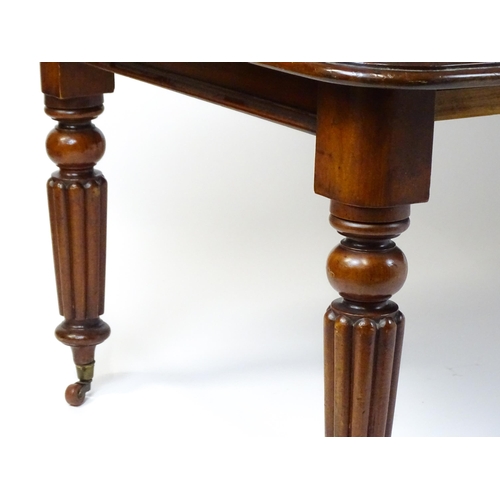 260 - A late 19thC mahogany dining table raised on four turned tapering legs terminating in porcelain cast... 