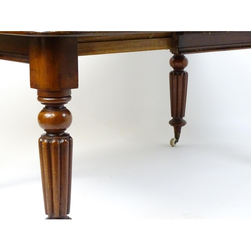 260 - A late 19thC mahogany dining table raised on four turned tapering legs terminating in porcelain cast... 