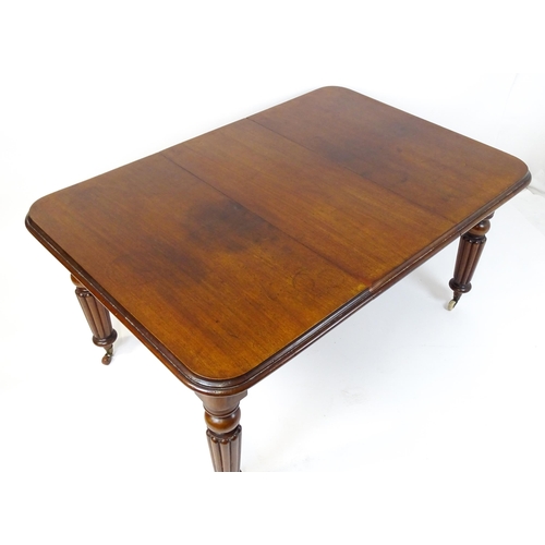 260 - A late 19thC mahogany dining table raised on four turned tapering legs terminating in porcelain cast... 