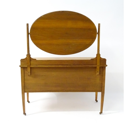 566 - An early 20thC dressing table with an oval mirror above two long drawers and raised on four tapering... 