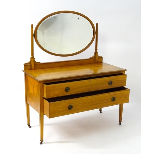 566 - An early 20thC dressing table with an oval mirror above two long drawers and raised on four tapering... 