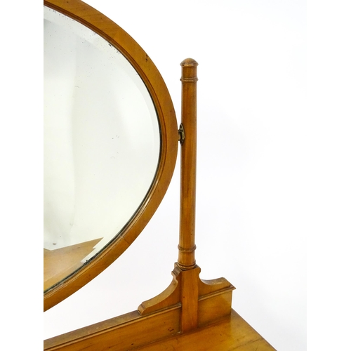 566 - An early 20thC dressing table with an oval mirror above two long drawers and raised on four tapering... 