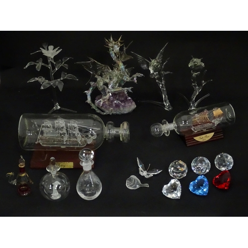 632 - A quantity of assorted glass ornaments to include a model of a dragon mounted on an amethyst specime... 