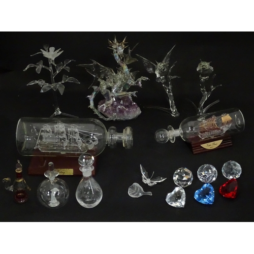 632 - A quantity of assorted glass ornaments to include a model of a dragon mounted on an amethyst specime... 