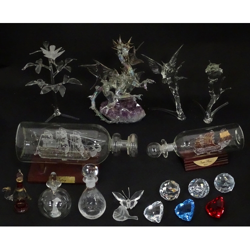 632 - A quantity of assorted glass ornaments to include a model of a dragon mounted on an amethyst specime... 