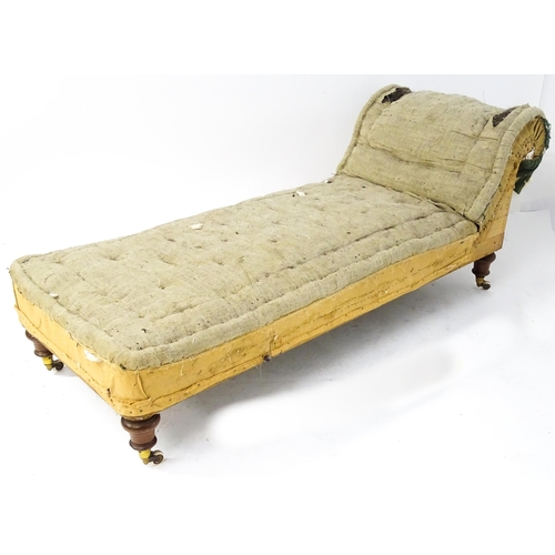 261 - A Victorian chaise longue / day bed, the mahogany frame with scrolling end and raised on four turned... 