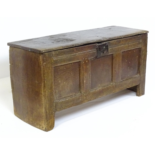 1 - An 18thC oak coffer / sword chest with a hinged lid above a panelled front raised on stile feet. 41