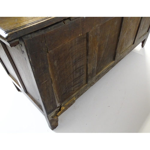 6 - An 18thC oak coffer with a hinged lid above four carved floral panels raise on stile feet. 59