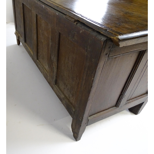 6 - An 18thC oak coffer with a hinged lid above four carved floral panels raise on stile feet. 59