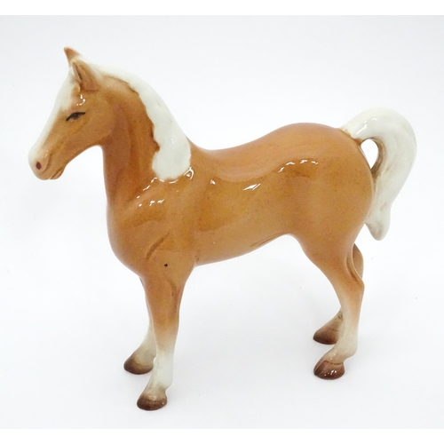 534 - A Beswick style model of a palomino horse. Approx. 7 1/4