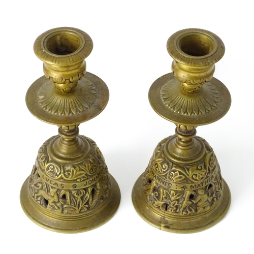 634 - A pair of 20thC cast brass candlesticks with openwork decoration and apostle detail to base. Approx.... 