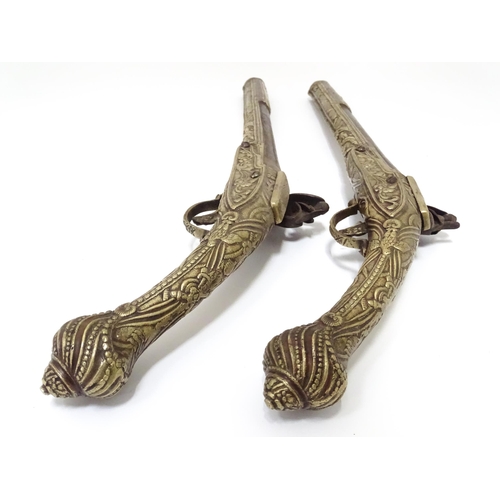 343 - A pair of mid 20thC decorative / display Eastern flintlock pistols, each constructed from brass with... 