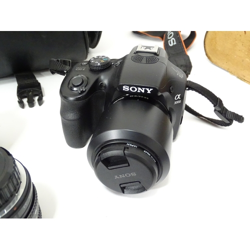 249 - A quantity of assorted cameras and accessories to include a Sony Alpha 3000 DSLR, a Sony DCR-SX44, a... 